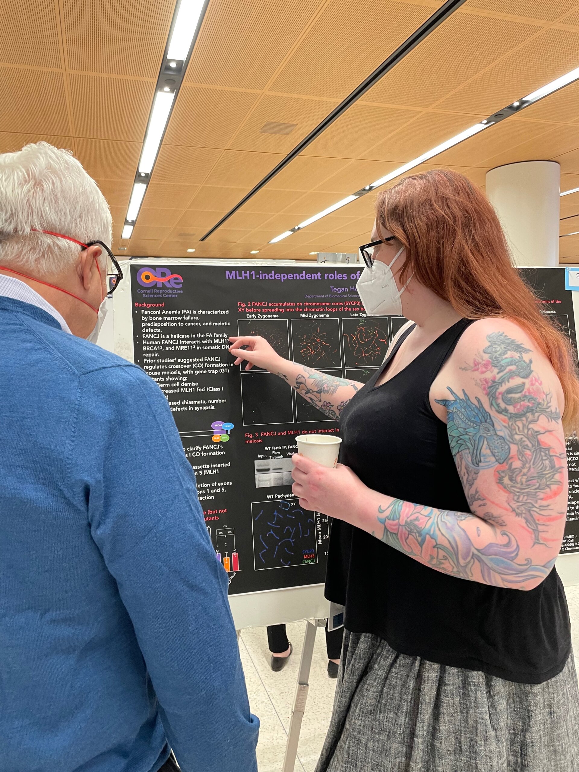 Dr. Tegan Horan and an attendee discussing a scientific poster display