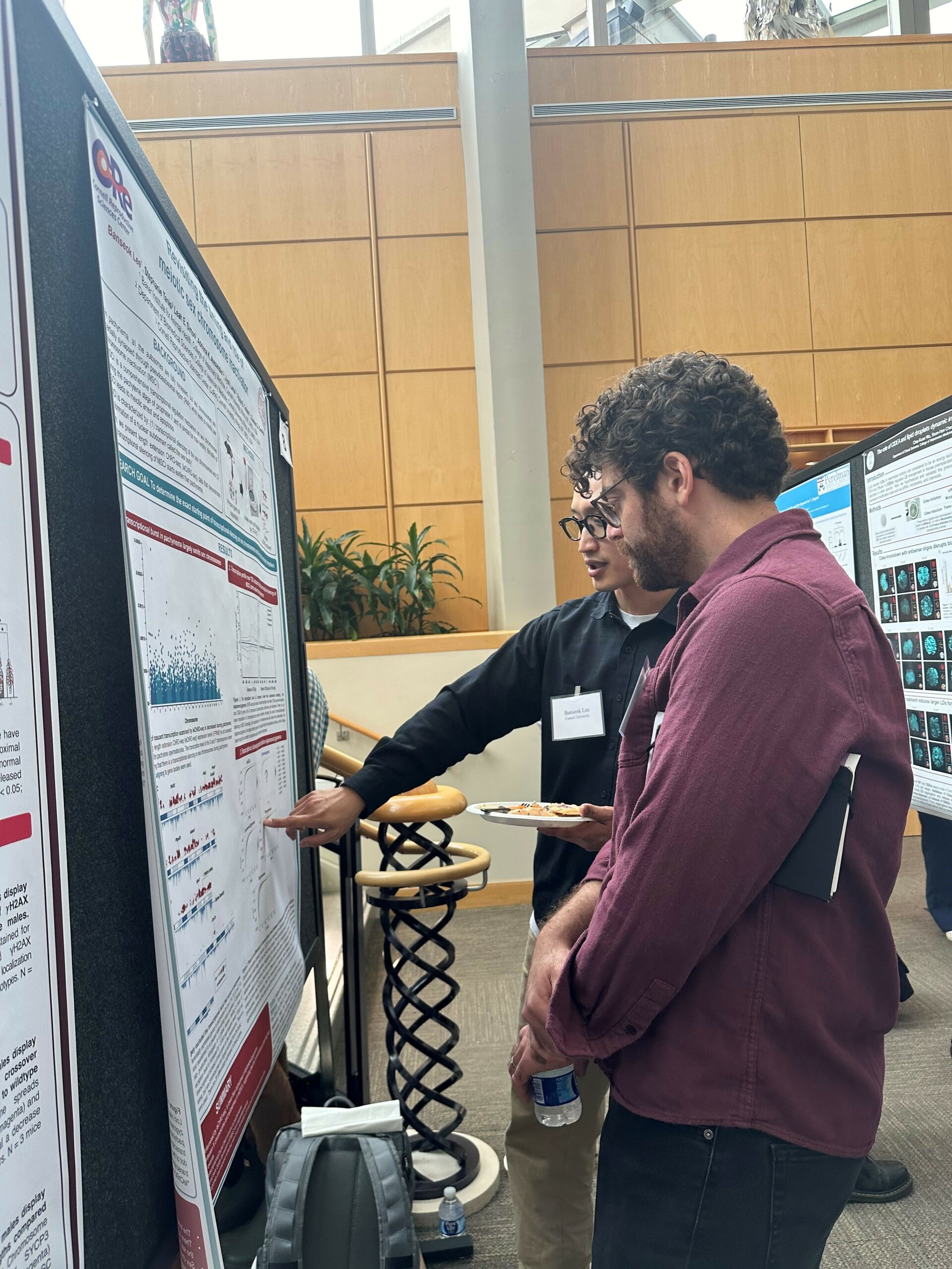 Ian Wolff and Banseok Lee discussing a poster at the Tri-Repro poster session